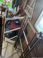 Two wooden drying rack panels leaning against wall showing structure and dowels