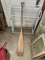 Full view of the wooden paddle front side showing blade and shaft