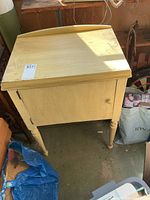 Front view of closed painted wood sewing cabinet