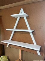front view showing three-tier white wooden tree-shaped wall shelf
