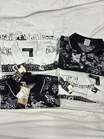 All four folded polo shirts displaying both print styles and attached tags
