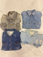 All four folded denim jackets showing colors and pockets