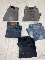 Five folded pairs of jeans in various washes