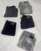 All five pairs folded showing back pockets and labels