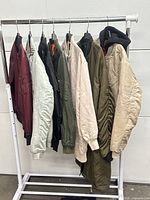 Front view of all seven bomber jackets on rack
