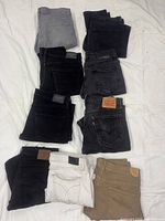 Nine folded jeans laid out showing colour variety