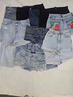 Front view of stacked denim shorts showing variety of washes and styles