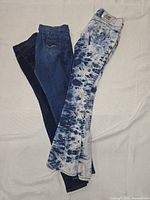 All three pairs of jeans laid out to show styles and colours