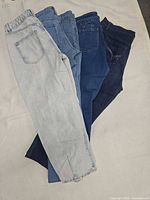 Four of the five jeans fanned out showing assorted washes