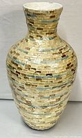 Front view of tall mosaic vase showing overall shape and tile pattern