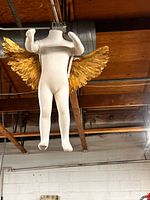 Front angled view showing full mannequin and gold wings