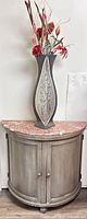 Front view of half-moon cabinet with marble top and vase arrangement