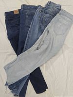 All five pairs of jeans overlapped showing color range