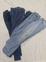 Six jeans fanned out showing washes and styles