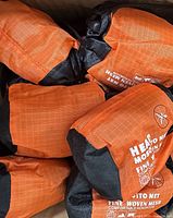 Group of orange and black pouch-packed head nets inside shipping box