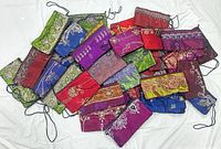 Pile of 33 colourful embroidered fabric handbags