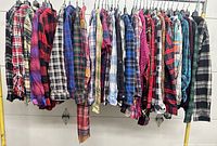 Full rack of assorted plaid flannel shirts hung on hangers