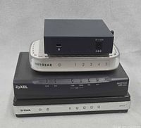 Stacked view of all four networking devices showing brand labels and relative sizes
