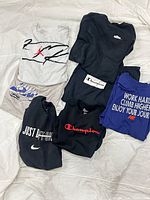 All seven t-shirts laid out showing graphics and colors
