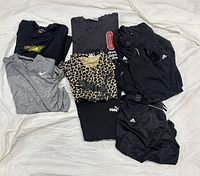 Eight folded men’s XXL t-shirts showing mix of Nike, Puma, Adidas logos