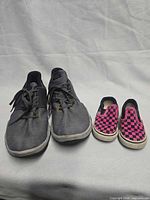 Pair of Nike men's shoes and Vans toddler shoes side by side