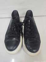 top view of both sneakers showing croc-embossed pattern and laces