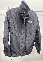 Front view of black The North Face jacket on hanger