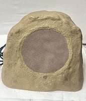 Front view of rock-style subwoofer showing grille and enclosure texture
