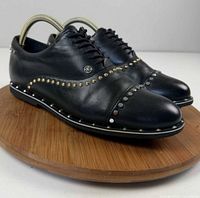Three-quarter view of both shoes showing leather, studs, laces
