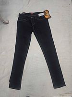 Full view of dark wash Dickies women's jeans laid flat