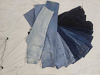 Fan layout showing all 13 pairs of jeans in varying washes