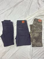 Three pairs of folded pants side by side