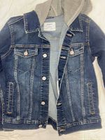 Front view of denim jacket showing hood, pockets, button closure