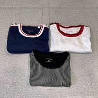 Three folded t-shirts showing colours and collars