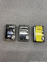 Front view of three Olympus Stylus Tough cameras showing body colours and branding