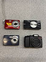 Front view of four Kodak cameras showing lens types and colours
