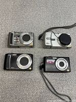 Front view showing all four Lumix cameras with lenses and finish colours