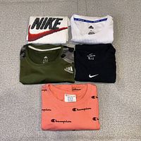 Five folded athletic shirts displayed