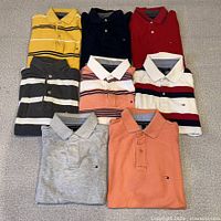 All eight Tommy Hilfiger polo shirts laid out in two rows