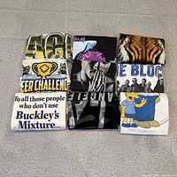 All nine folded t-shirts displayed front graphic visible