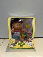 Front view of boxed Cabbage Patch Kids Babies Sylphia Fabiola doll showing doll, accessories and packaging