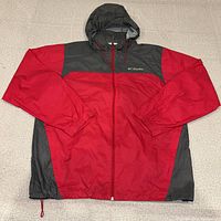 Front view of Columbia red and grey hooded windbreaker laid flat