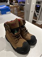 Front three-quarter view showing both boots, toe guards, laces, and overall condition