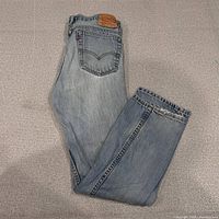 Full view of folded Levi's 516 jeans front and back light wash