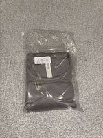 Shirt folded inside clear plastic bag with label visible