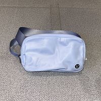 Front view of light blue Lululemon belt bag showing logo and overall shape