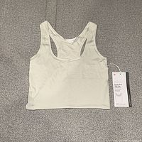 Front view of light green Lululemon Nulu tank top with hangtag attached