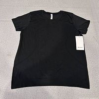 Front view of black short sleeve tee with tags