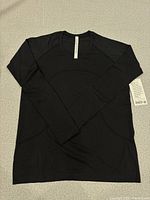 Front view of black long sleeve shirt laid flat