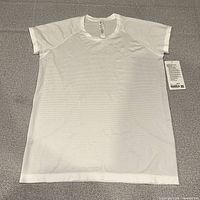 Full front view of white Lululemon Swiftly Tech Short Sleeve 2.0 with tags attached
